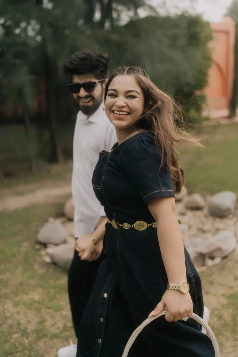 Couple laughing as they walk through a garden