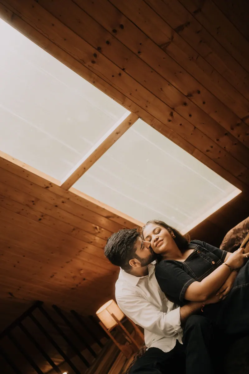 Couple embracing under a wooden skylight in a mountain cabin