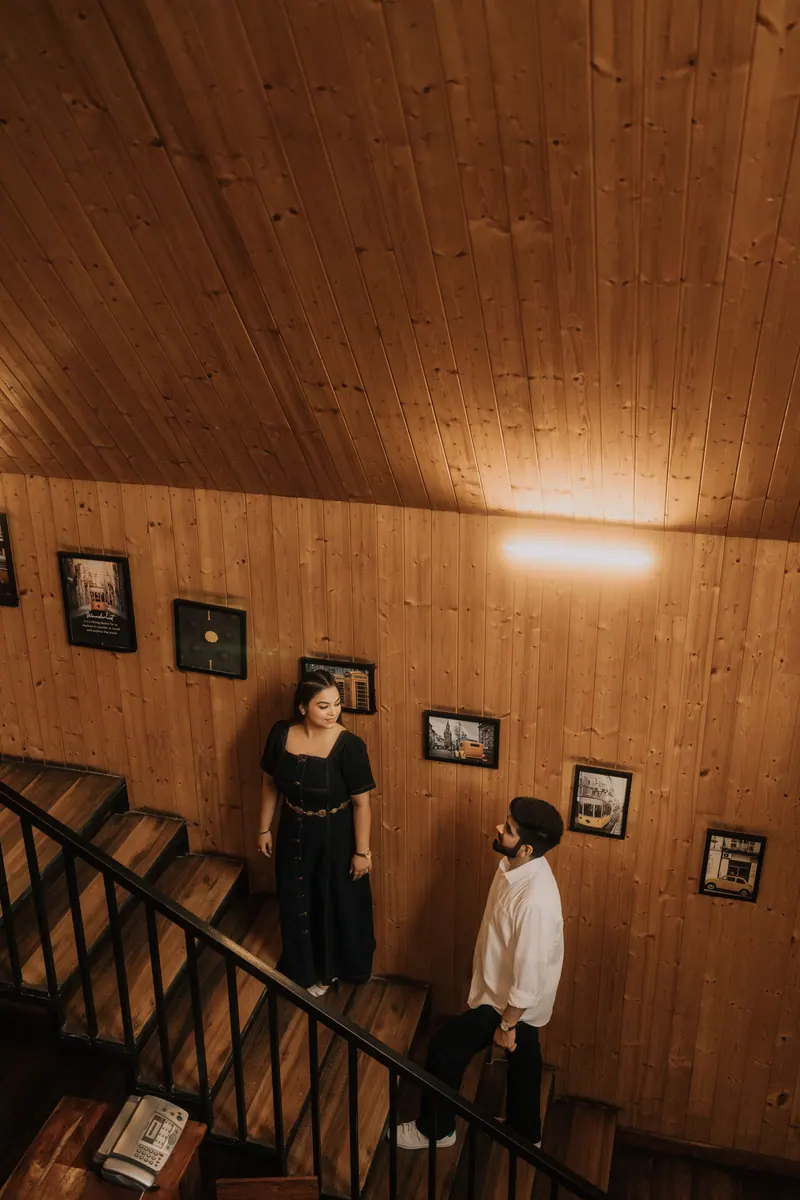 Couple on the wooden stairs of a mountain cabin during their pre-wedding shoot