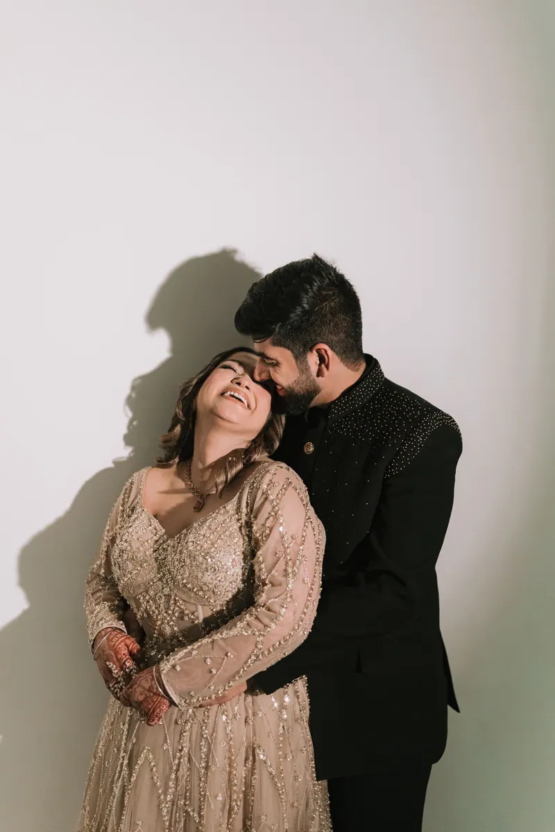 Bride laughing with her head on the groom’s shoulder