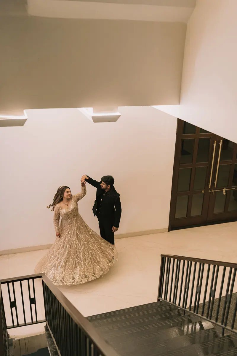 Bride and groom twirling in a softly lit hotel hall at their reception